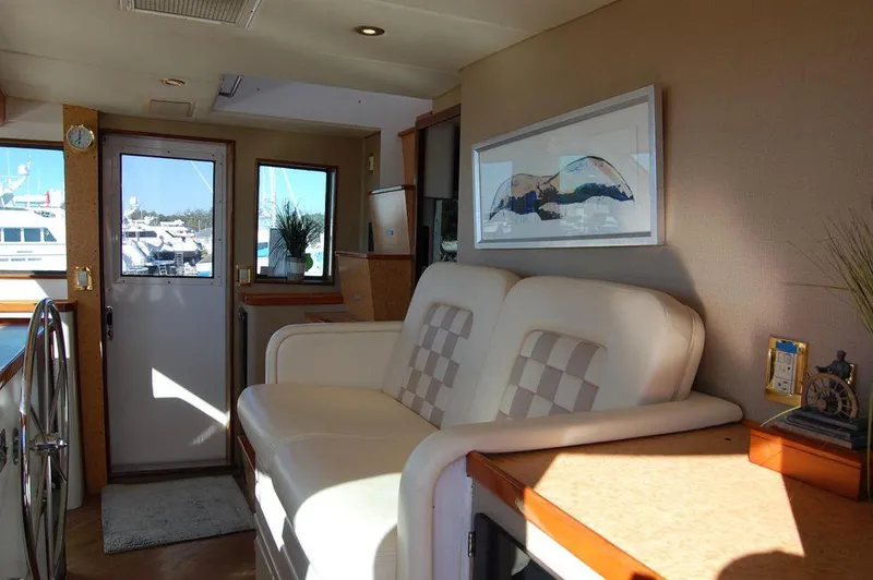 Slide: The Image of Interior of 1990 Hatteras 78 Aft Cockpit Motoryacht with white seating and nautical decor. - 12