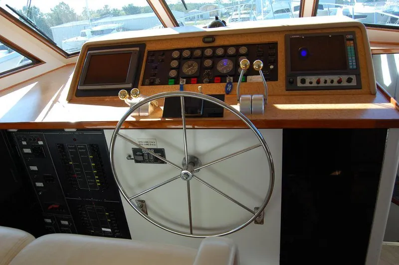 Slide: The Image of Hatteras 78 Aft Cockpit Motoryacht 1990 helm station with steering wheel and control panel. - 13