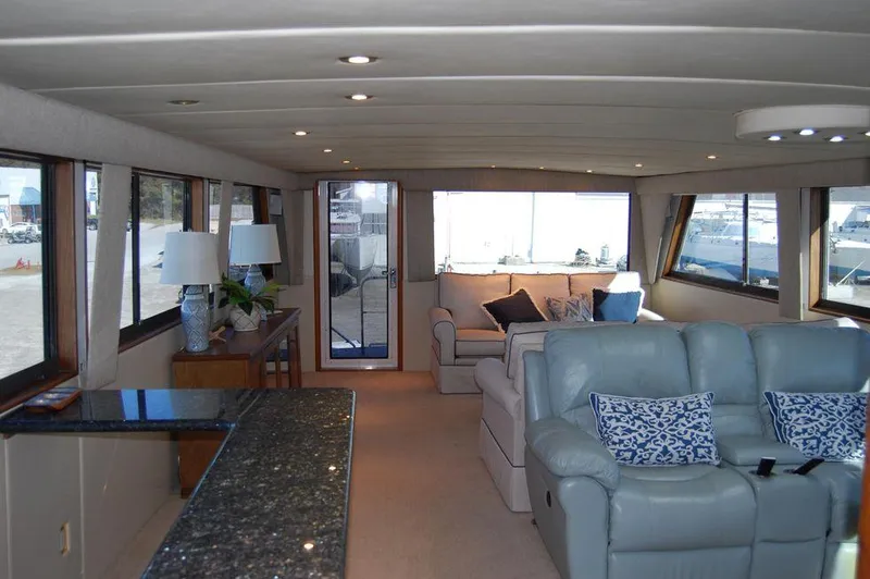 Slide: The Image of Luxurious interior of 1990 Hatteras 78 Aft Cockpit Motoryacht with plush seating and large windows. - 18