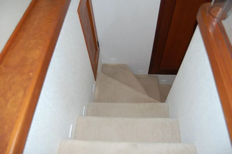 Slide: The Image of Staircase in 1990 Hatteras 78 Aft Cockpit Motoryacht with carpeted steps and wooden handrails. - 21