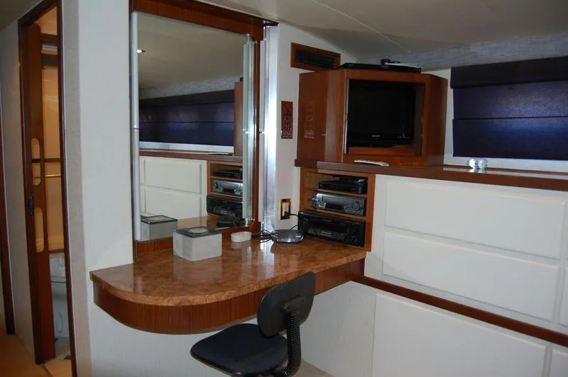 Slide: The Image of 1990 Hatteras 78 Aft Cockpit Motoryacht interior with desk, mirror, and entertainment center. - 24