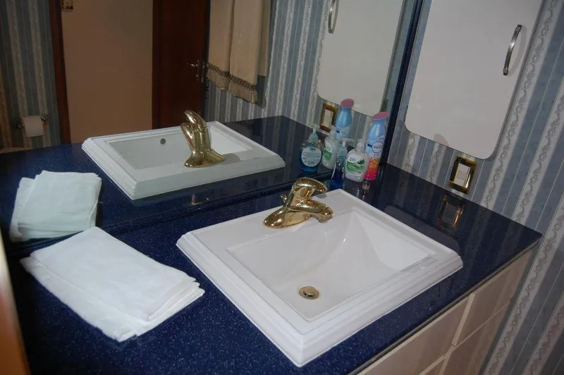 Slide: The Image of Bathroom sink area in 1990 Hatteras 78 Aft Cockpit Motoryacht with blue countertop. - 26