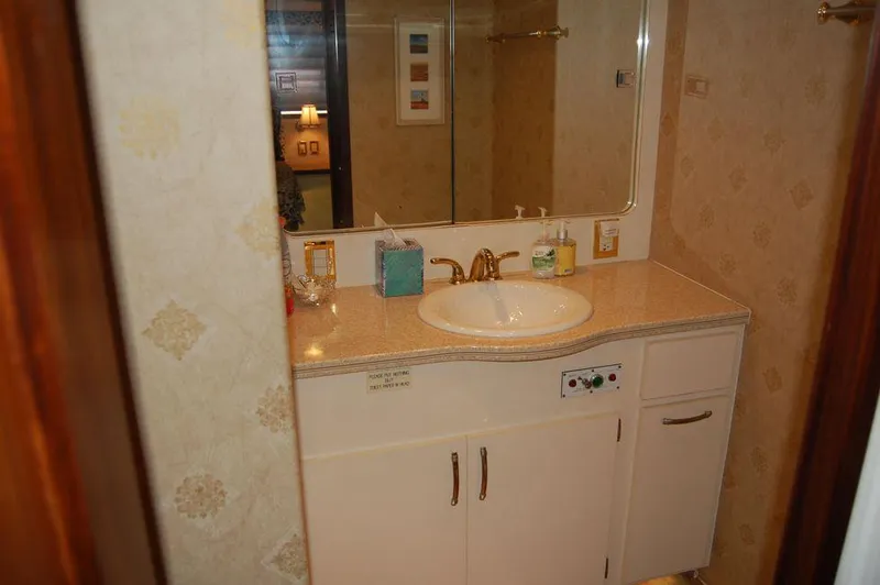 Slide: The Image of Bathroom vanity in 1990 Hatteras 78 Aft Cockpit Motoryacht with sink and mirror. - 33