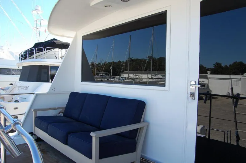 Slide: The Image of 1990 Hatteras 78 Aft Cockpit Motoryacht with blue cushioned seating on deck. - 34