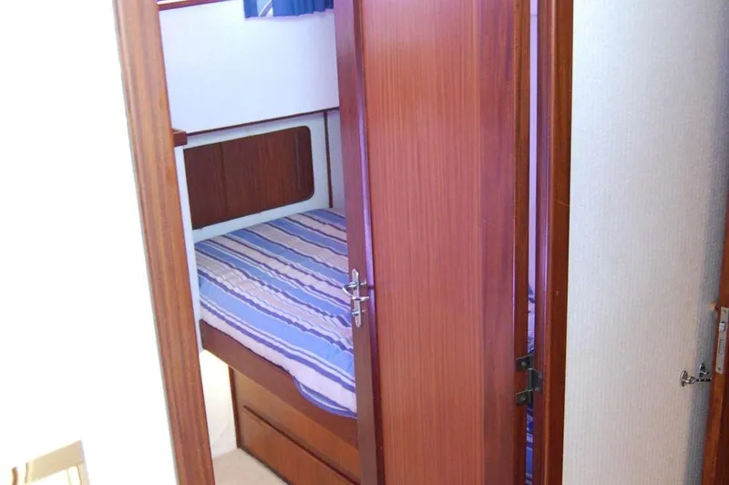 Slide: The Image of Small bedroom with striped bedding on a 1990 Hatteras 78 Aft Cockpit Motoryacht. - 43