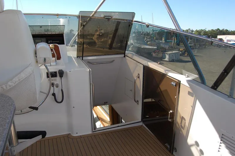 Slide: The Image of 1990 Hatteras 78 Aft Cockpit Motoryacht helm station with open cabin door. - 6