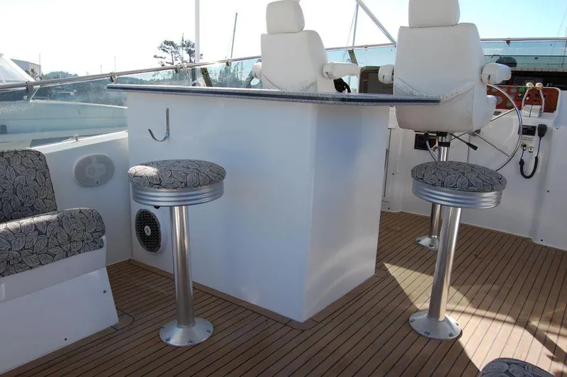 Slide: The Image of Cockpit seating area of 1990 Hatteras 78 Aft Cockpit Motoryacht with bar stools and helm chairs. - 7