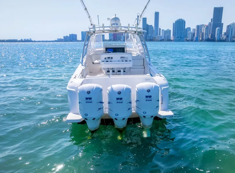 Slide: The Image of 2011 Intrepid 400 Cuddy boat with triple engines on water, city skyline in background. - 10