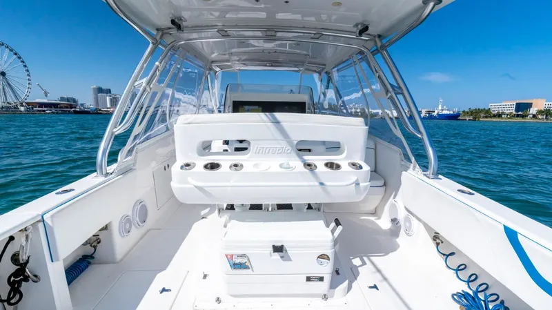 Slide: The Image of 2011 Intrepid 400 Cuddy boat interior with ocean view and cityscape background. - 14