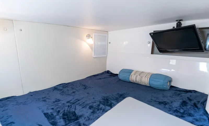 Slide: The Image of 2011 Intrepid 400 Cuddy cabin with blue bedding and mounted TV. - 24
