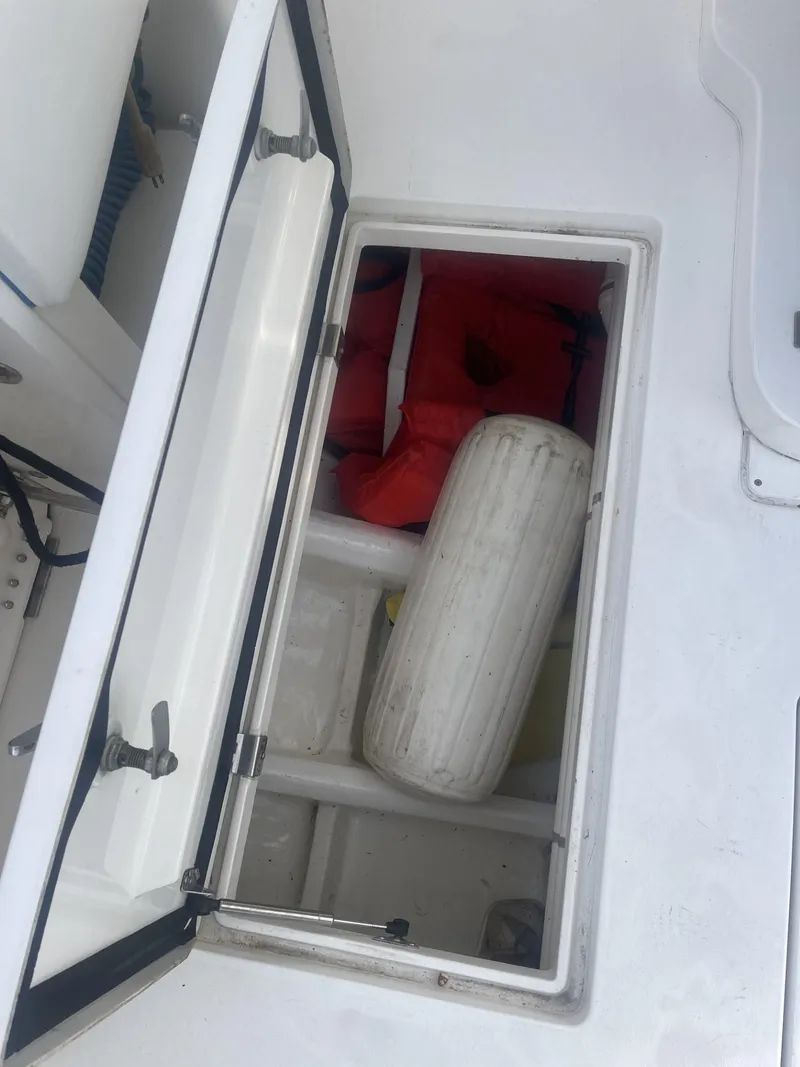 Slide: The Image of Storage compartment on a 2011 Intrepid 400 Cuddy boat with life jackets and a fender. - 29