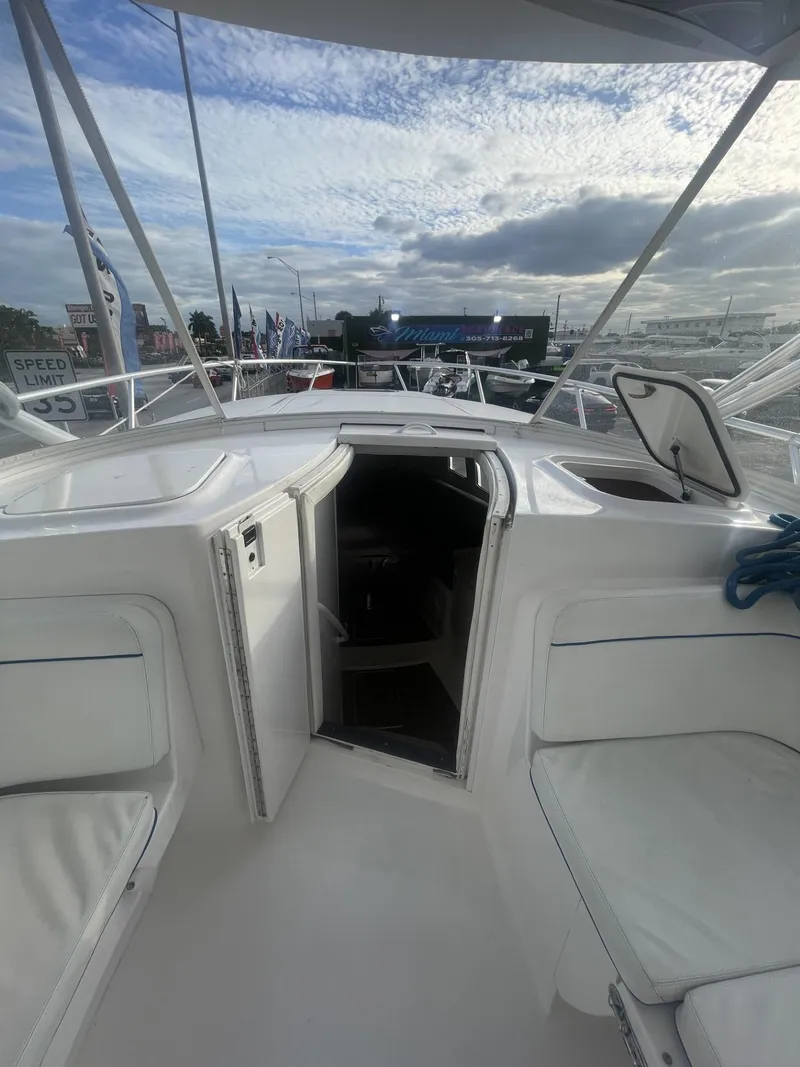 Slide: The Image of 2011 Intrepid 400 Cuddy boat interior with open cabin door under a cloudy sky. - 36