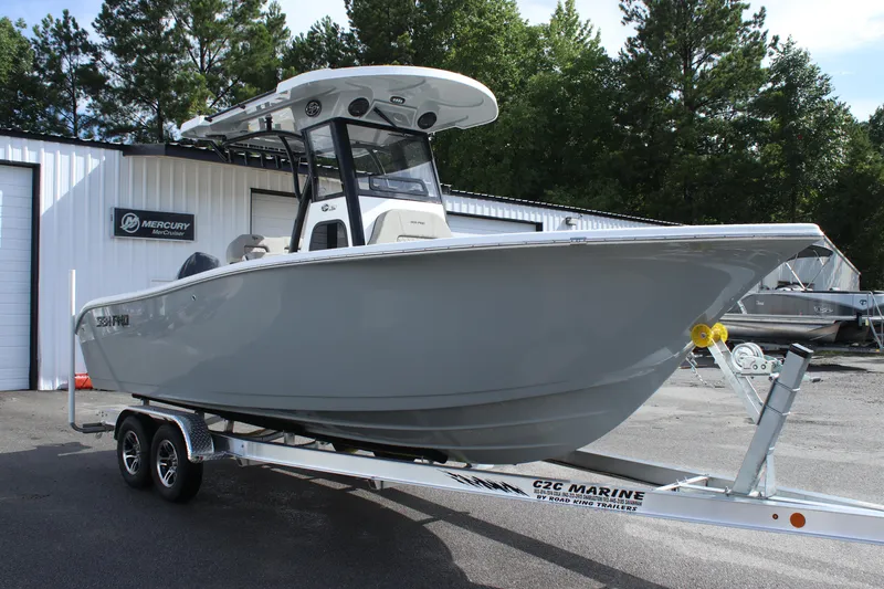 Slide: The Image of 2025 Sea Pro 242 Deep-V boat on a trailer outside a marine dealership. - 1