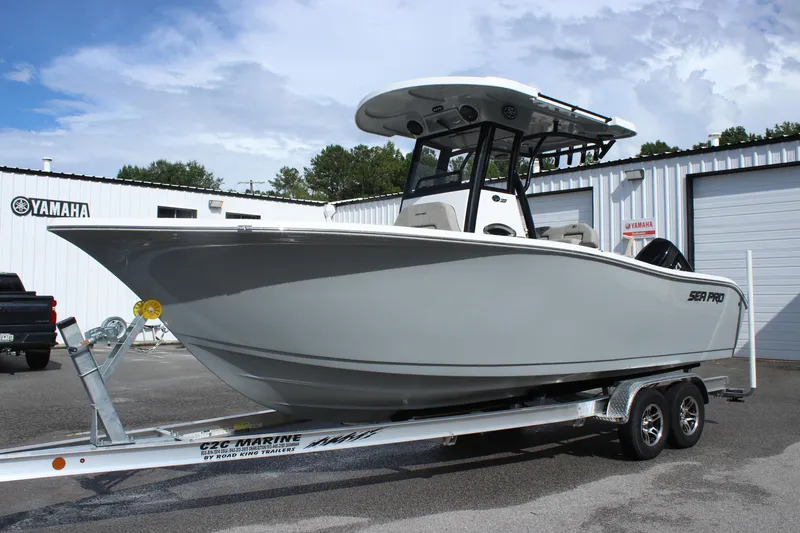 Slide: The Image of 2025 Sea Pro 242 Deep-V boat on a trailer in a marina. - 2