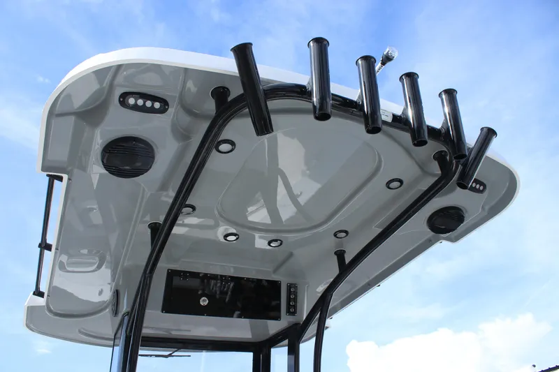 Slide: The Image of 2025 Sea Pro 242 Deep-V boat hardtop with rod holders and speakers against blue sky. - 20
