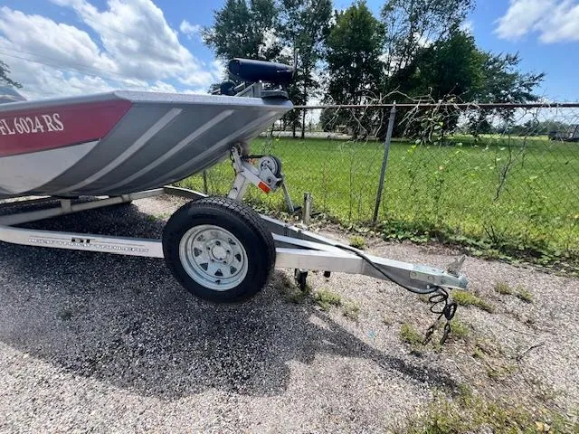 Slide: The Image of 2017 Express XP7 boat on trailer, parked on gravel near chain-link fence. - 9