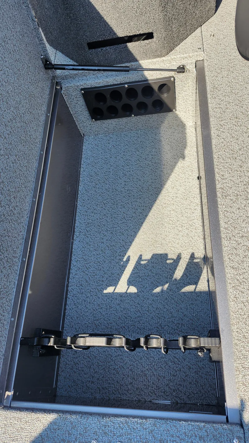 Slide: The Image of 2025 Lund 1875 Fisherman boat interior storage compartment with rod holders. - 17