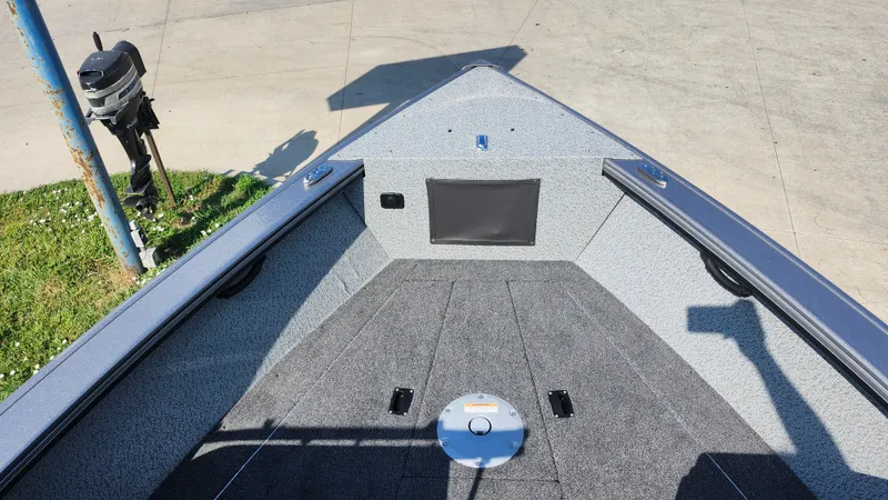 Slide: The Image of 2025 Lund 1875 Fisherman boat interior with carpeted deck and storage compartments. - 19