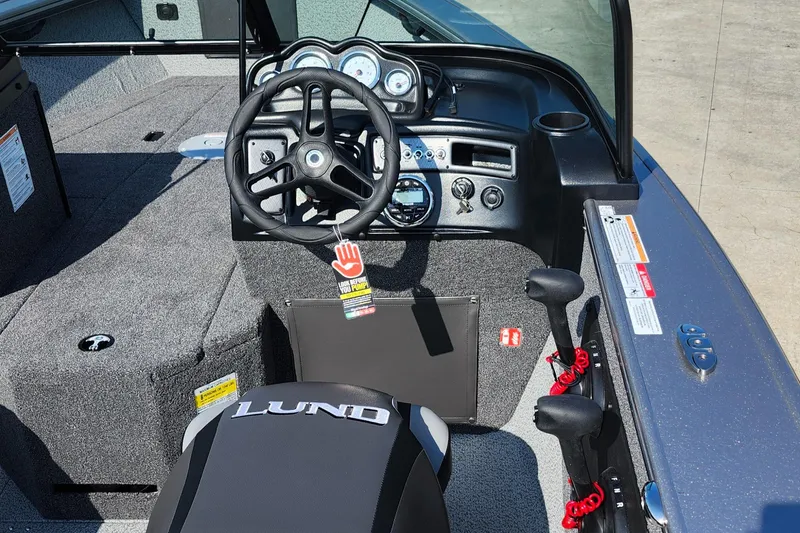 Slide: The Image of 2025 Lund 1875 Fisherman boat interior with steering wheel and dashboard controls. - 22