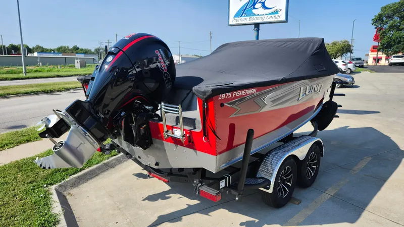 Slide: The Image of 2025 Lund 1875 Fisherman boat with cover on trailer, parked outdoors. - 7