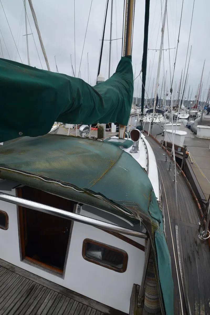 Slide: The Image of 1978 Cheoy Lee Offshore 32 sailboat docked at marina, green canvas cover. - 10