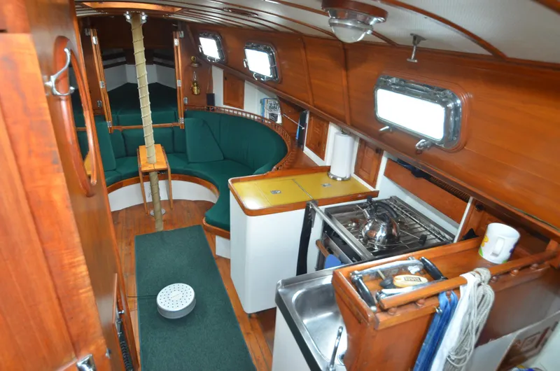 Slide: The Image of 1978 Cheoy Lee Offshore 32 yacht interior with wood paneling and compact kitchen. - 18