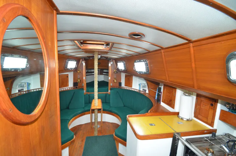 Slide: The Image of Interior of 1978 Cheoy Lee Offshore 32 sailboat with wood paneling and green seating. - 19