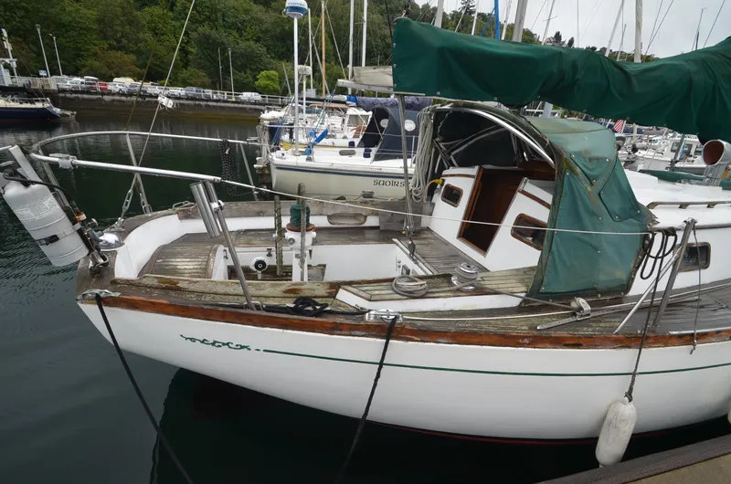 Slide: The Image of 1978 Cheoy Lee Offshore 32 sailboat docked in a marina, featuring a wooden deck and green canopy. - 2