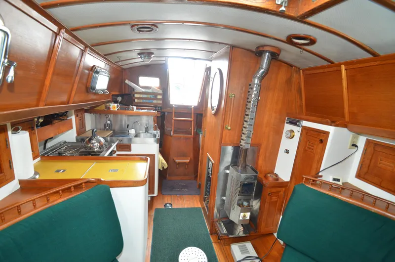 Slide: The Image of 1978 Cheoy Lee Offshore 32 yacht interior with wood paneling and compact kitchen. - 20