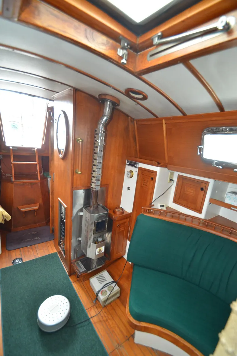 Slide: The Image of Interior of 1978 Cheoy Lee Offshore 32 sailboat with wood paneling and green seating. - 22