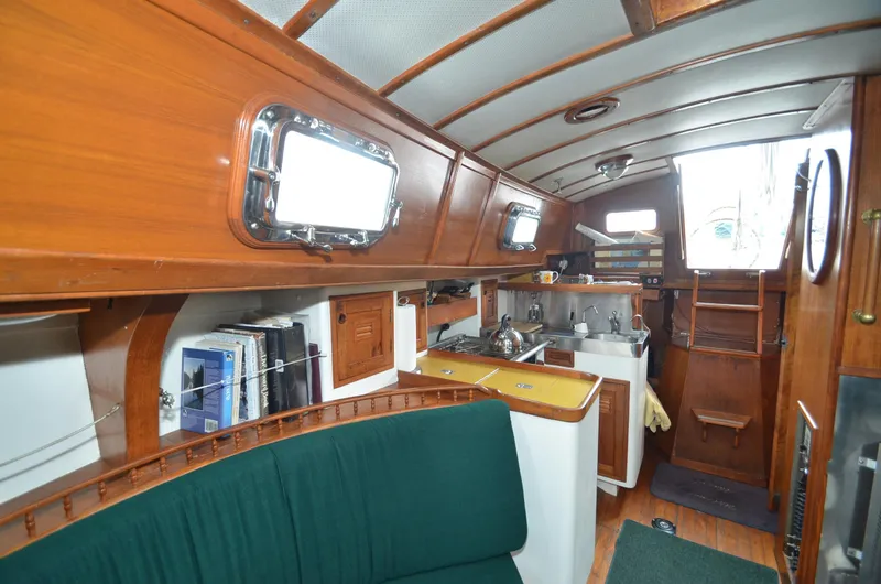 Slide: The Image of 1978 Cheoy Lee Offshore 32 yacht interior with wood paneling and compact kitchen area. - 23