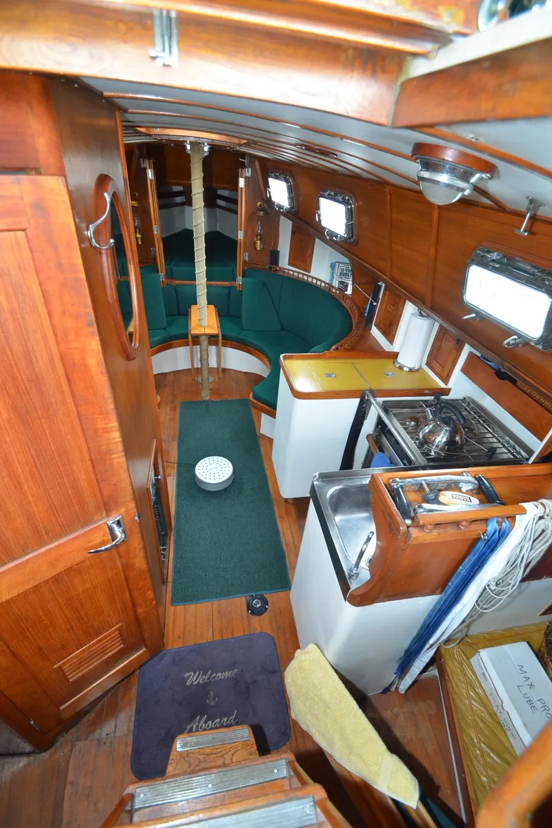 Slide: The Image of 1978 Cheoy Lee Offshore 32 yacht interior with wood paneling and compact kitchen. - 25