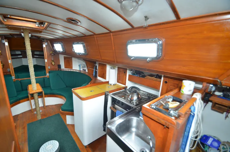 Slide: The Image of 1978 Cheoy Lee Offshore 32 yacht interior with wood finish and compact kitchen area. - 26