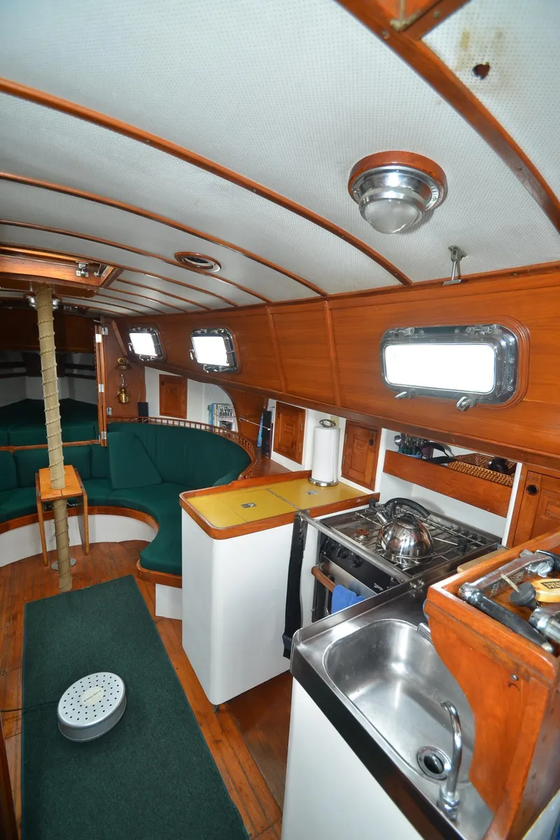 Slide: The Image of 1978 Cheoy Lee Offshore 32 yacht interior with wood finish and compact kitchen. - 28