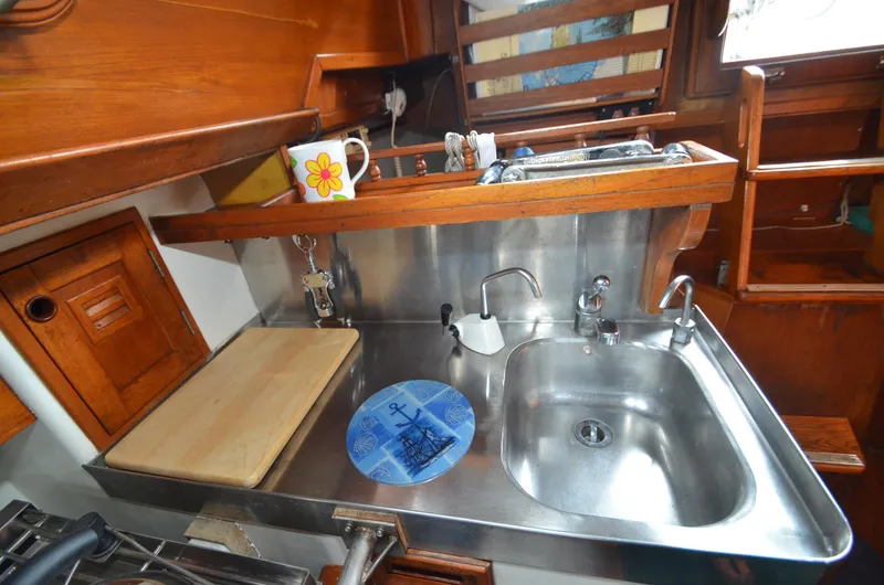 Slide: The Image of 1978 Cheoy Lee Offshore 32 yacht kitchen with stainless steel sink and wooden cabinetry. - 29