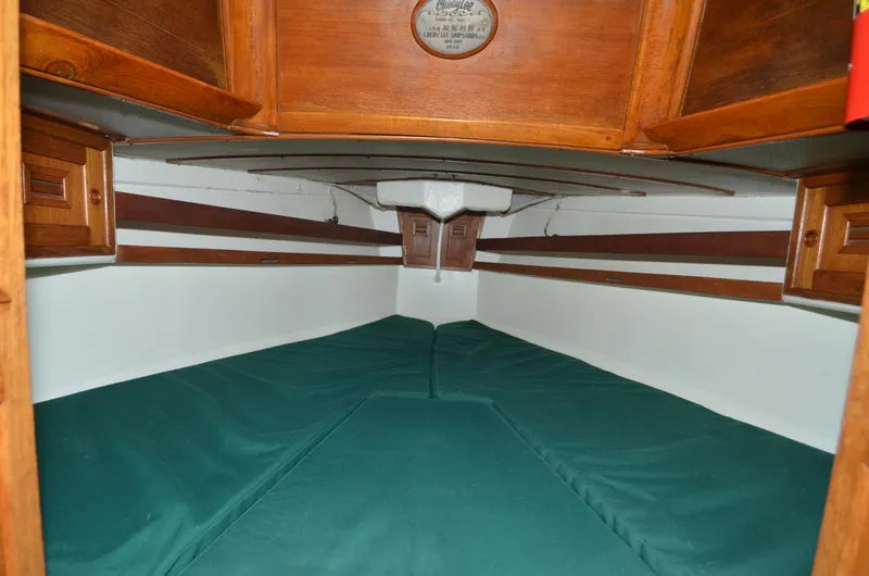Slide: The Image of 1978 Cheoy Lee Offshore 32 cabin interior with green cushions and wooden accents. - 30