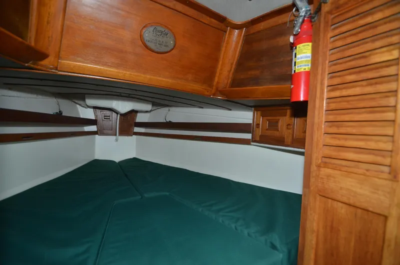 Slide: The Image of 1978 Cheoy Lee Offshore 32 cabin interior with wood paneling and green cushions. - 31