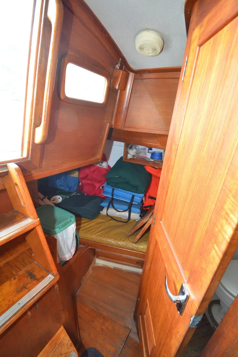 Slide: The Image of 1978 Cheoy Lee Offshore 32 cabin interior with wooden finish and storage space. - 33