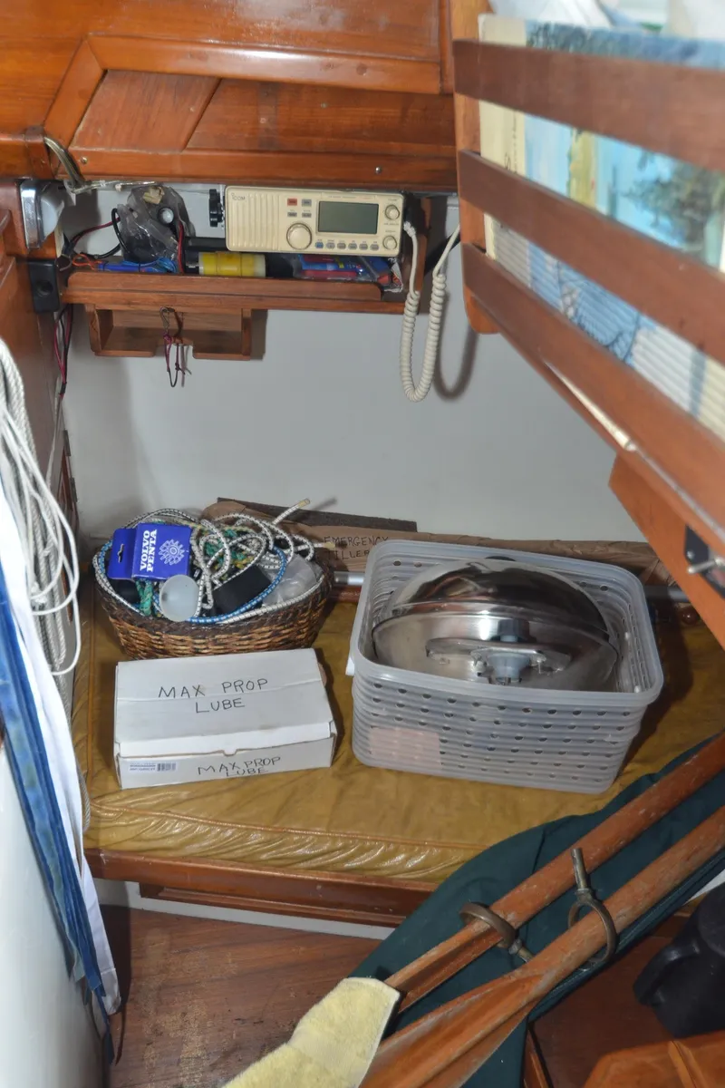 Slide: The Image of 1978 Cheoy Lee Offshore 32 cabin with radio, storage baskets, and nautical equipment. - 34