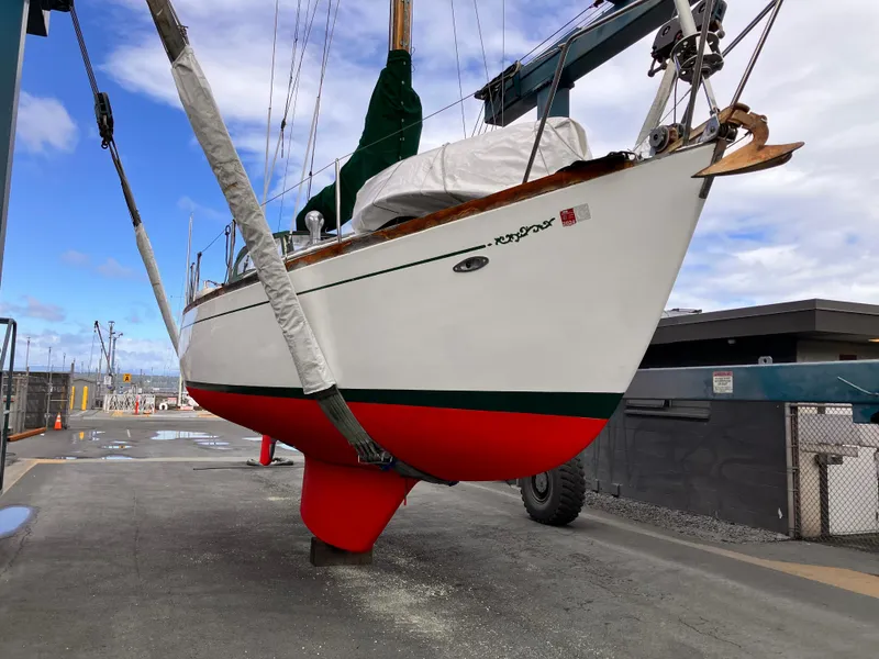 Slide: The Image of 1978 Cheoy Lee Offshore 32 sailboat with vibrant red hull in a shipyard. - 42