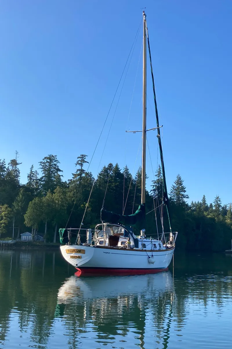 Slide: The Image of 1978 Cheoy Lee Offshore 32 sailboat on calm water, surrounded by trees. - 49