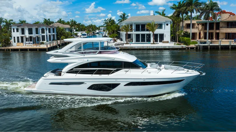 Slide: The Image of 2018 Princess F62 yacht cruising in a scenic waterfront neighborhood. - 2