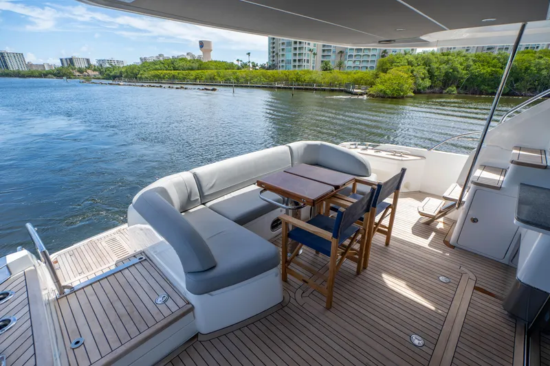 Slide: The Image of 2018 Princess F62 yacht deck with seating and dining area, overlooking serene waterfront. - 5