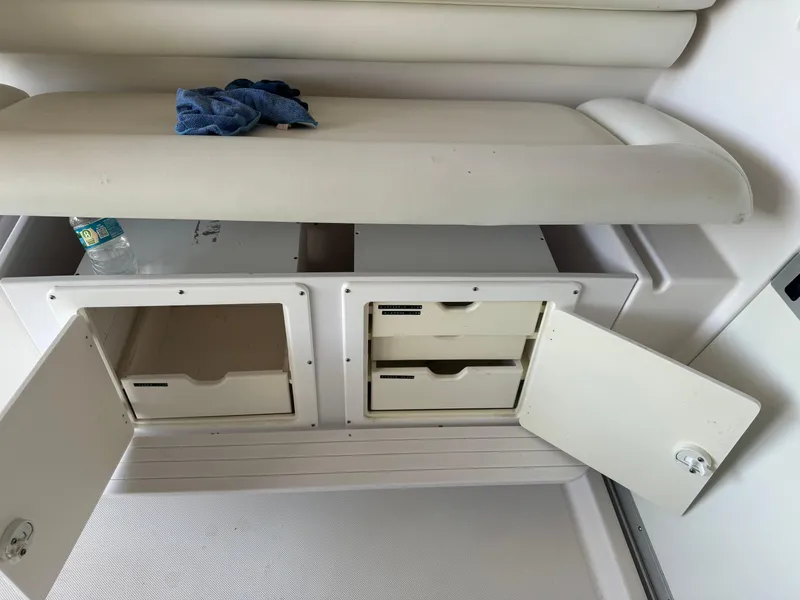 Slide: The Image of 2006 Pro-Line 32 Express boat storage compartments with open doors and seating area. - 15