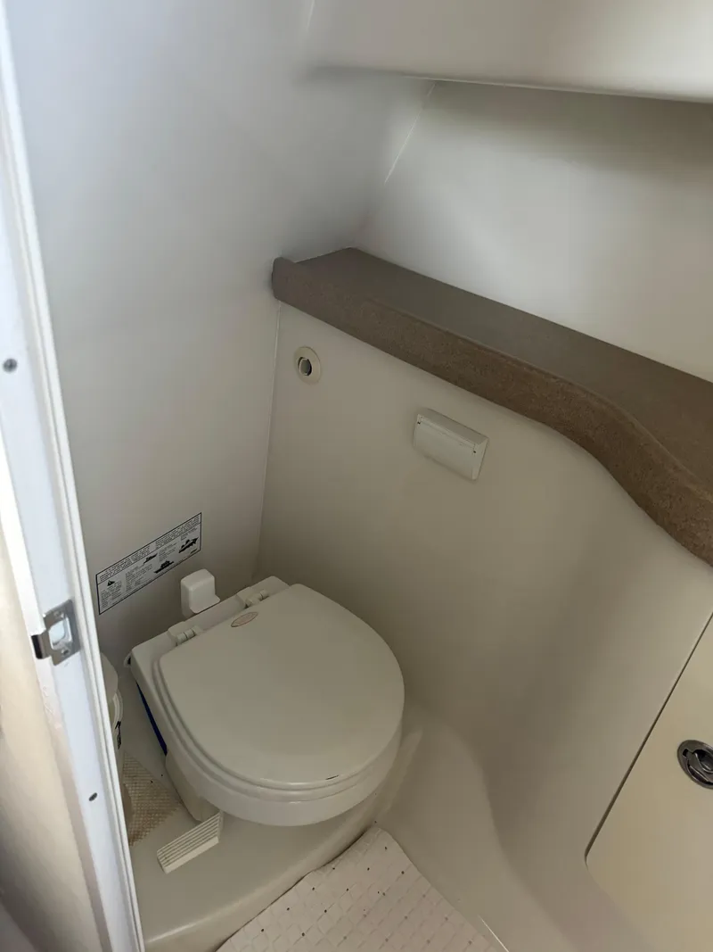 Slide: The Image of 2006 Pro-Line 32 Express boat bathroom interior with toilet and storage. - 18