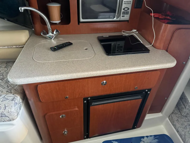 Slide: The Image of 2006 Pro-Line 32 Express boat kitchenette with sink, microwave, and mini fridge. - 20