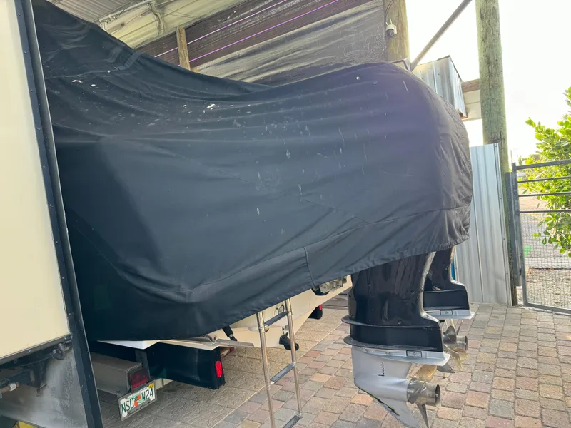 Slide: The Image of 2006 Pro-Line 32 Express boat covered, stored outdoors on brick pavement. - 31