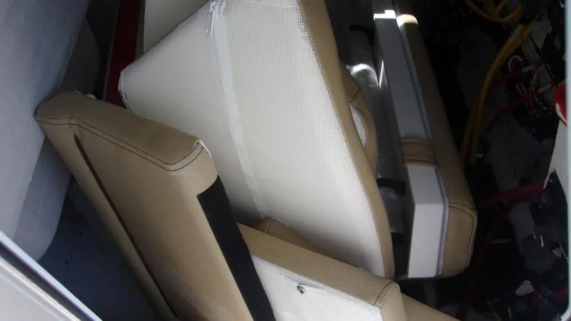 Slide: The Image of Interior seating of 2025 Sportsman Heritage 231 CC boat, featuring beige cushions. - 18