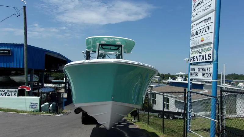 Slide: The Image of 2025 Sportsman Heritage 231 CC boat at marina, front view, blue sky background. - 4