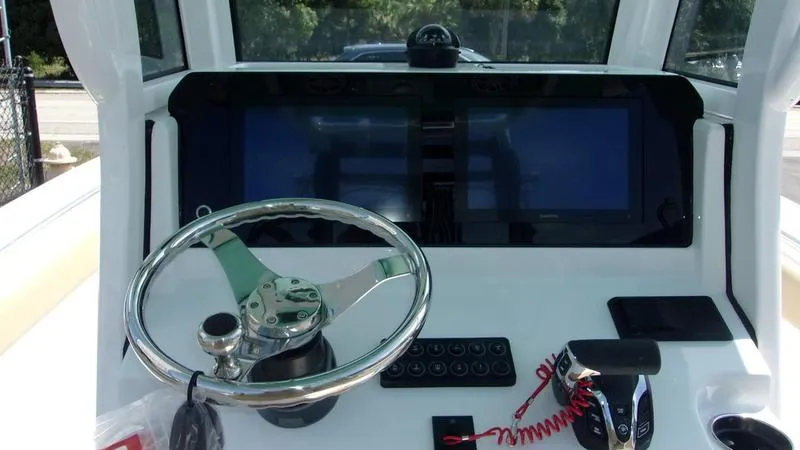 Slide: The Image of 2025 Sportsman Heritage 231 CC boat dashboard with steering wheel and controls. - 9